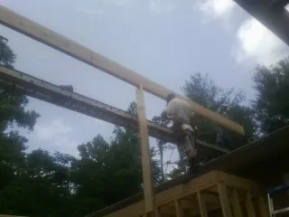 Carpenter setting a ridge beam over a new addition frame — Ice Dam Removal by Roofing Brothers in Hollow Rock