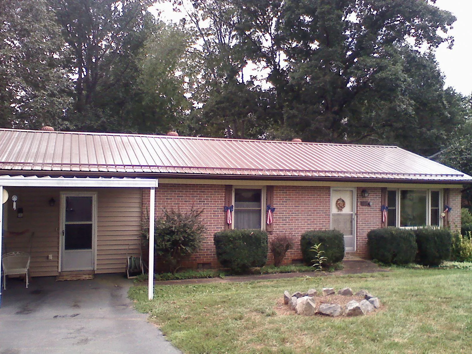 Bronze metal roof and carport on a brick ranch home — Roof Repair work by our crew in Hollow Rock